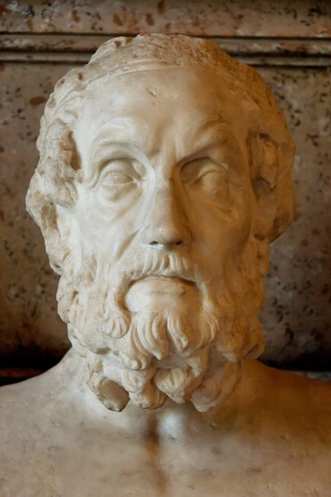 Reprodução em pedra de quem seria Homero. Homem com barba cabelos médios.