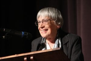 Autora idosa em close, palestrando