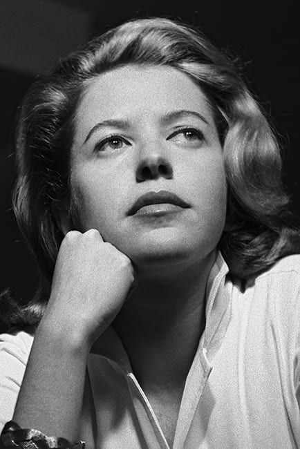 Foto de rosto em preto e branco. Hilda jovem, com o rosto apoiado na m]ao direita fechada