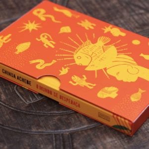 detalhe da luva do livro, em cor laranja, com desenhos tribais em amarelo